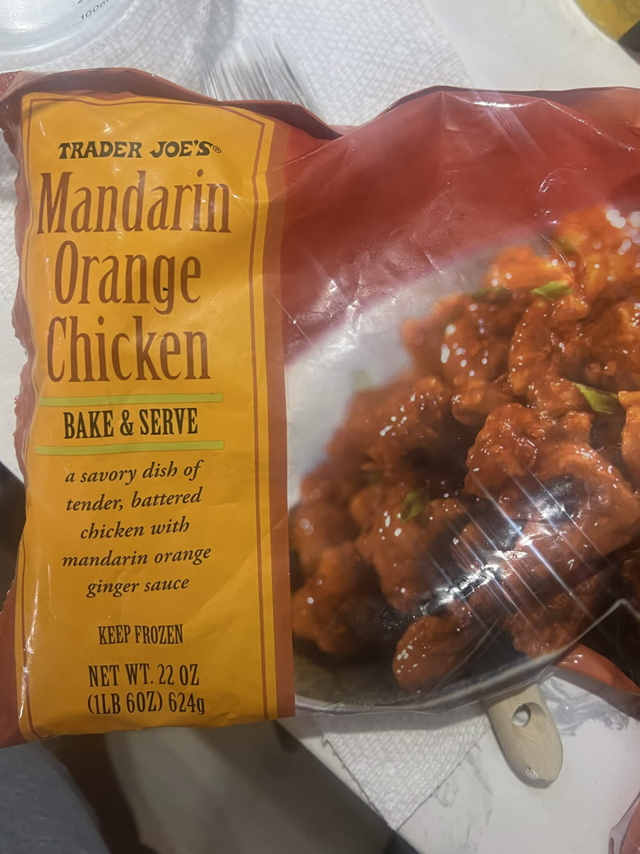 The front of the Trader Joe's Mandarin Orange Chicken bag: bake and serve, a savory dish of tender battered chicken with mandarin orange ginger sauce, keep frozen, 22 oz